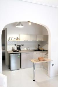 沃洛斯Hope home的厨房配有白色橱柜和桌子