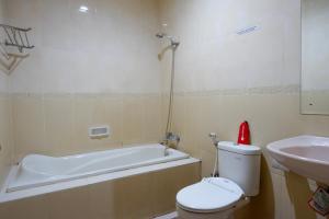 ParepareRedDoorz near Monumen Habibi Ainun的带浴缸、卫生间和盥洗盆的浴室