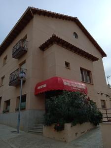 Castejón del Puente卡萨巴兰科旅馆的前面有红色遮阳篷的建筑