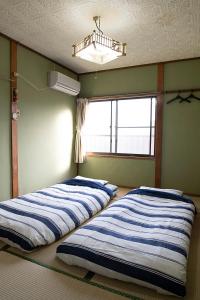 田边市TSUKASA HOUSE English OK Kumano Kodo experience Lodge Close to station 無料駐車場あり的带窗户的客房内的两张床