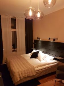克里斯蒂安斯塔德Hotell Kong Christian的一间卧室配有一张大床和两个灯