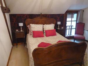 Sainte-Catherine-de-FierboisL'arum antique的一间卧室配有一张带红色枕头的大床