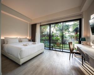 武里南T-REX BURIRAM BOUTIQUE HOTEL New Hotel in Buriram的一间卧室设有一张床和一个大窗户