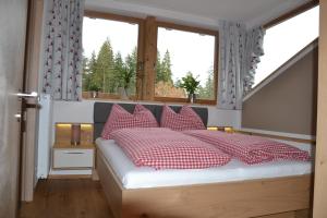 Brandhof的一间卧室配有红色和白色枕头的床