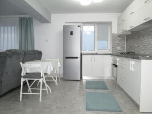 特尔戈维什泰Apartament Sarra的厨房配有白色冰箱和桌椅
