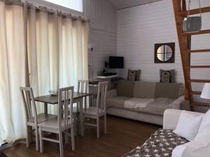 加桑Saint tropez -parc oasis的客厅配有桌椅和沙发