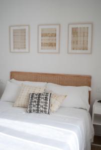 蒙泰罗通多L'Alighieri的一张铺有白色床单的床和两张墙上的照片