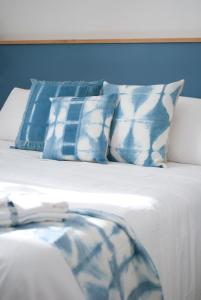 蒙泰罗通多L'Alighieri的一张带蓝色和白色枕头的床
