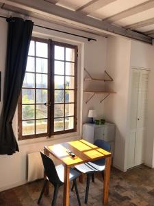 图尔Appartement spacieux avec une vue sur Tours ( 38m²) -Gite de Bellevue的窗户客房内的桌椅