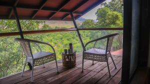 纳西克Jungle Safari Resort & Holiday Villa的享有森林景致的门廊上的2把椅子