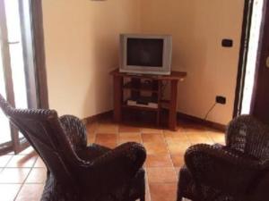 科克瑞诺Villa Laura的客厅配有两把椅子和电视