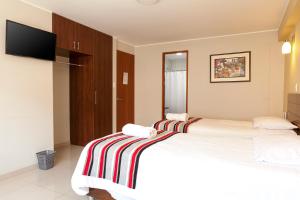 瓦努科Mauri的酒店客房设有两张床和电视。