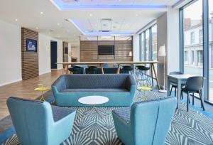 格里姆斯比格里姆斯比智选假日酒店的一个带蓝色椅子和桌子的办公室大堂
