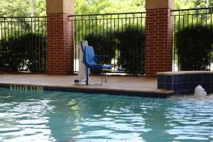 迪尔帕克Holiday Inn Express & Suites Deer Park, an IHG Hotel的游泳池旁的蓝色椅子