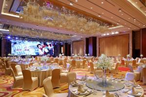 绍兴绍兴世茂皇冠假日酒店的宴会厅配有桌椅和屏幕
