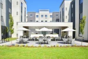 小石城住桥套房酒店 - 小石城 - 医疗中心的一个带桌椅和遮阳伞的庭院