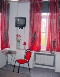 Oberthal苏尔埃施酒店的一间设有红色椅子、一张桌子和一台电视的房间
