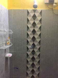 高兰兰达旅馆的配有黑色和白色瓷砖墙的淋浴
