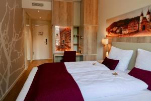 海德堡Rafaela Hotel Heidelberg的配有一张床和一张书桌的酒店客房