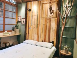 台南醒覺旅人-訂房後需聯繫轉帳的一间卧室设有木墙和床