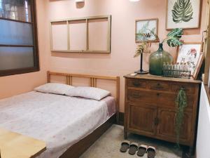 台南醒覺旅人-訂房後需聯繫轉帳的一间卧室配有一张床和一个木制梳妆台