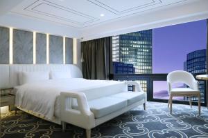 南京南京中心大酒店的卧室配有一张白色大床和一把椅子