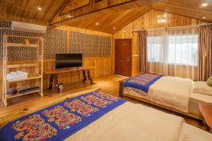 龙胜龙安酒店的一间卧室配有两张床和电视。