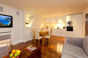 伦敦Tavistock Place Apartments的一间带桌子的客厅和一间厨房
