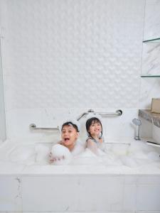 马尼拉Shangri-La The Fort, Manila的两个孩子坐在浴缸里