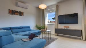 普拉Exclusive City Apartments的客厅配有蓝色的沙发和电视