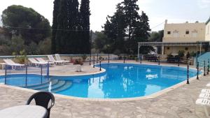 帕诺尔莫斯卡里莫斯Ilias Studios sevasti的一座带蓝色水和白色椅子的大型游泳池