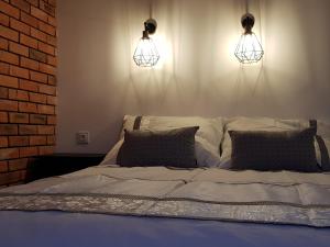 格利维采MISVEST Maria IV Arena Gliwice的一张带两个灯和两个枕头的床