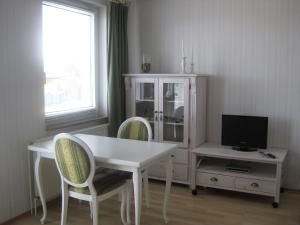 齐罗Ferienwohnung Meeresblick的客厅配有白色的桌椅和电视。