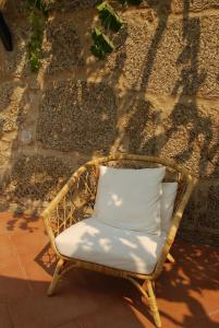 科维良Refúgio de Calheiros的墙上的藤椅和白色枕头