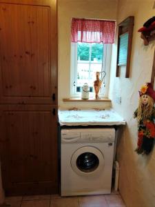 RingsendCarnowen Cottage的洗衣房配有洗衣机和窗户