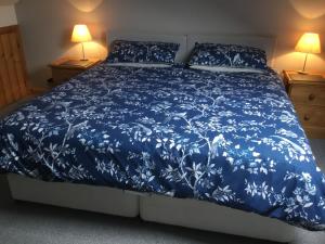 兰贝里斯泰德林博瑟农场酒店的一张带蓝色被子和两盏灯的床