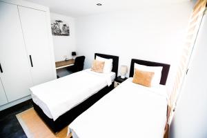帕拉马里博Bronbella Villa Residence的配有白色和橙色枕头的客房内的两张床