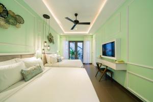 会安Lavini Hoian Boutique Villa的卧室配有一张白色大床和电视。