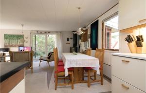 HelberskovNice Home In Hadsund With 2 Bedrooms And Wifi的厨房以及带桌椅的用餐室。