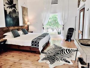卢甘维尔Sails Beach House的一间卧室配有一张床和斑马地毯