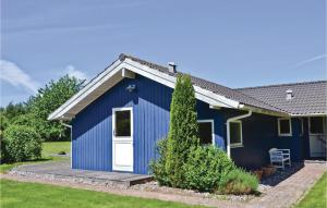 Udsholt SandLovely Home In Grsted With Wifi的院子里有白色门的蓝色棚子