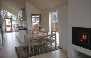 斯图伯克宾Amazing Home In Stubbekbing With 3 Bedrooms的一间带桌子和壁炉的用餐室