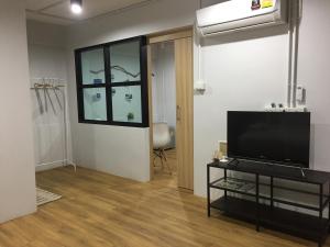甲米镇您好公寓的客厅配有平面电视和窗户。