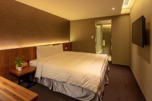台北谷墨商旅的酒店客房,配有床和电视
