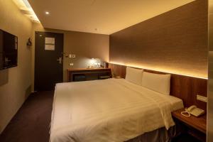 台北谷墨商旅的卧室配有白色大床和电话