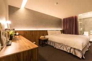 台北谷墨商旅的配有一张床和一张书桌的酒店客房