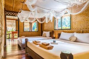 塞友桂河丛林竹筏度假村的带窗户的客房内的两张床
