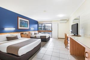 埃尔利海滩Reef Gateway Hotel的配有一张床和一台平面电视的酒店客房