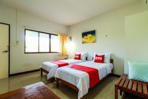 南奔OYO 421 Dnk Baan Suan的一间卧室配有两张红色和白色床单
