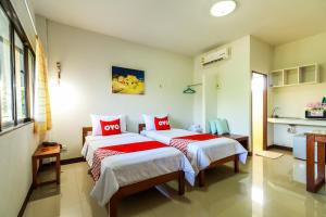 南奔OYO 421 Dnk Baan Suan的一间卧室配有两张带红色枕头的床